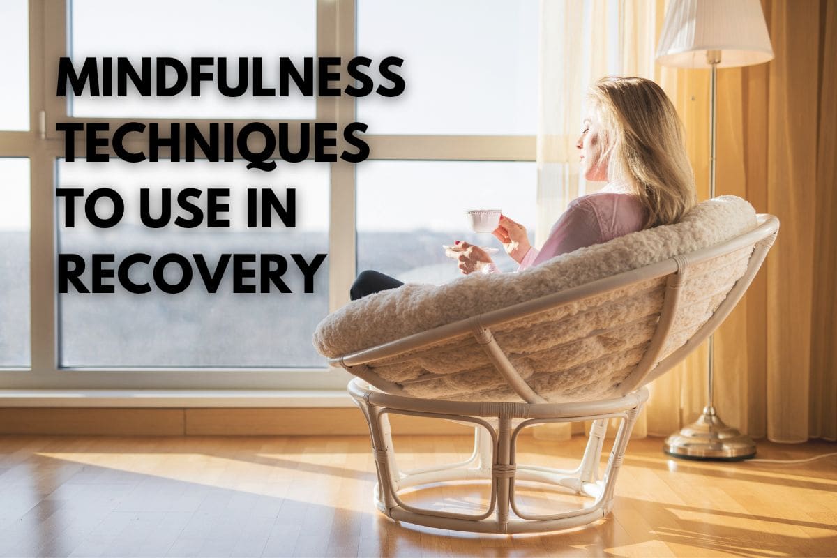 an image of a female sitting enjoying a hot drink while practicing mindfulness techniques in recovery.