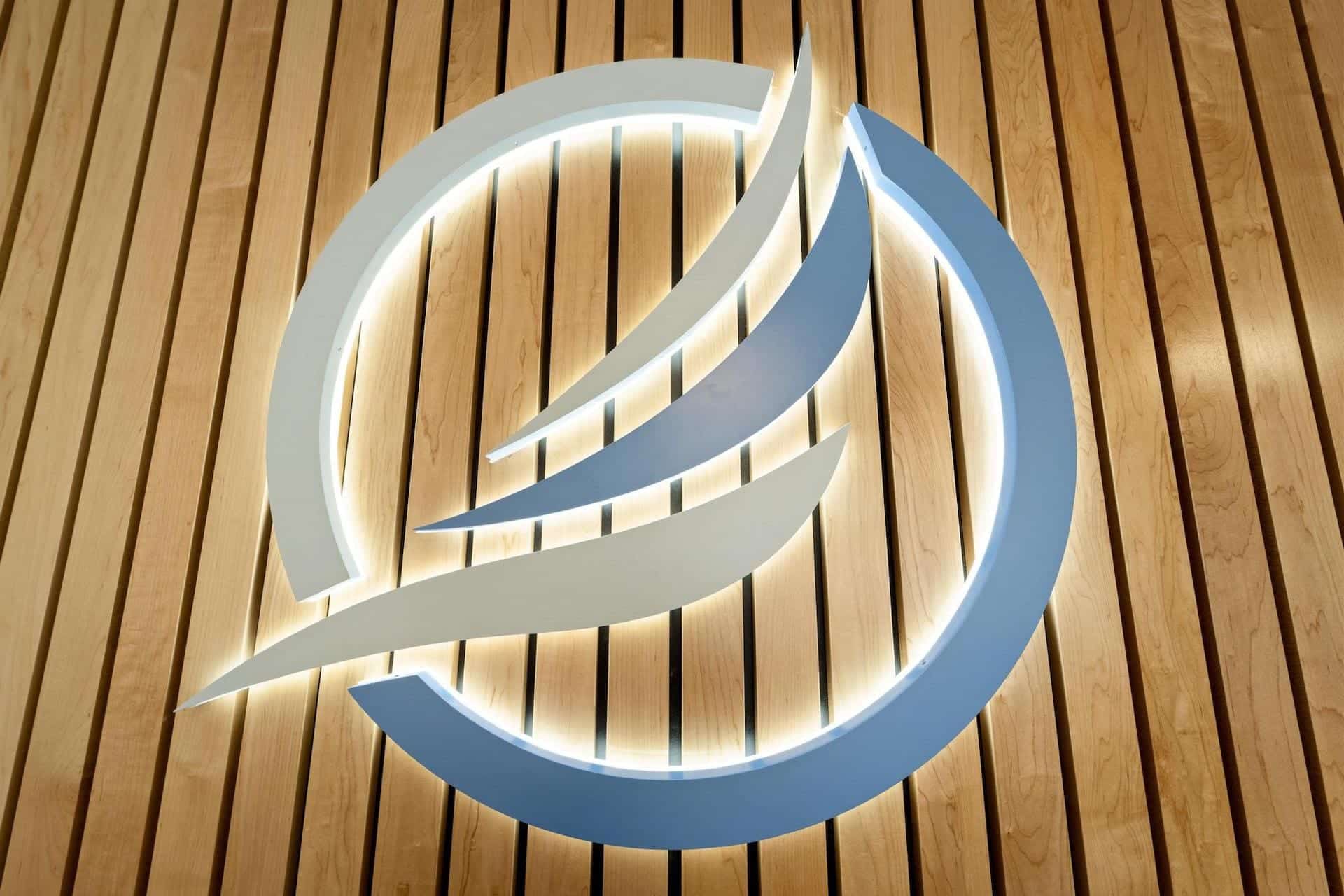 Blue and white abstract logo with wooden background.